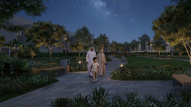 A shaded walkway under planted canopies at Al Ghadeer in the evening
