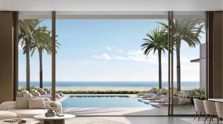 Living room of a Y Views villa opening through full-height glazing to the pool, palms and beach beyond.