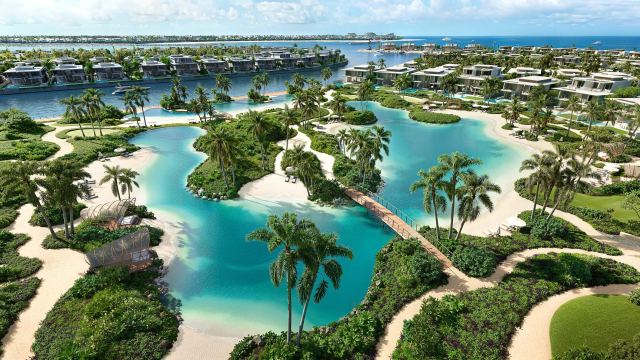 Swimmable lagoons with sandy edges and footbridges at Bay Estate