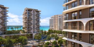 The towers of The Beach House Fahid seen from the podium gardens, with the beach behind.