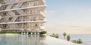 An infinity pool at the front of the podium at Fahid Beach Residences, parallel to the beach.