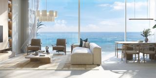 A living and dining room at Fahid Beach Terraces with the sea beyond the glass.