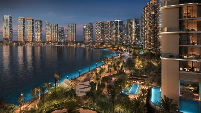 The Creekside at d3 at dusk, waterfront residences above the promenade and pools