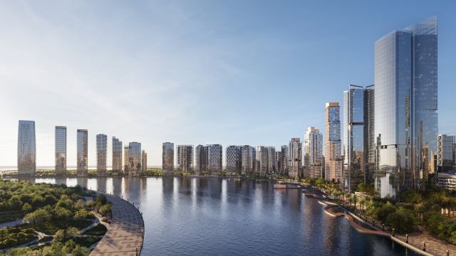 Promenade-level view along the water at Dubai Design District, with towers on both banks