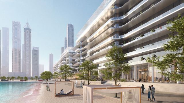 The beach at Dubai Harbour with shaded cabanas, the low-rise residences behind