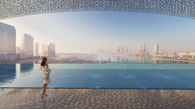 A rooftop infinity pool at Dubai Harbour looking across the water to the Dubai skyline