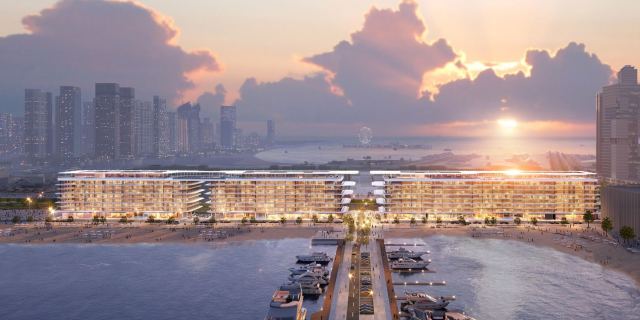 Dubai Harbour Residences seen from the water at sunset, a low-rise building running along the shoreline.