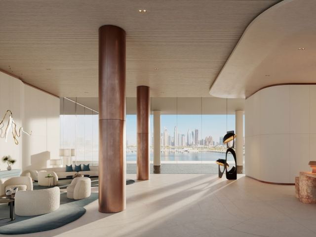 Reception lobby at Dubai Harbour Residences with sea views through full-height glass.