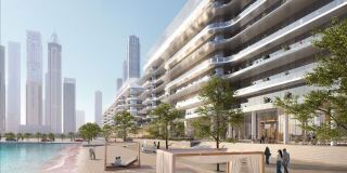 The private beach at Dubai Harbour Residences with shaded cabanas and the building behind.
