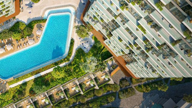 A pool and planted terraces between towers at Dubai Maritime City, seen from above
