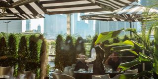 Shaded terrace dining in DIFC with the Dubai skyline beyond.