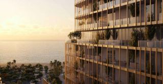 Facade of a HADO tower at sunset above the shoreline.