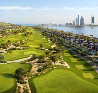 Aerial render of Hudayriyat Golf Estates with the golf course, villas and the Abu Dhabi skyline beyond.