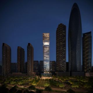 The Inaura tower standing among the Downtown Dubai skyline after dark.