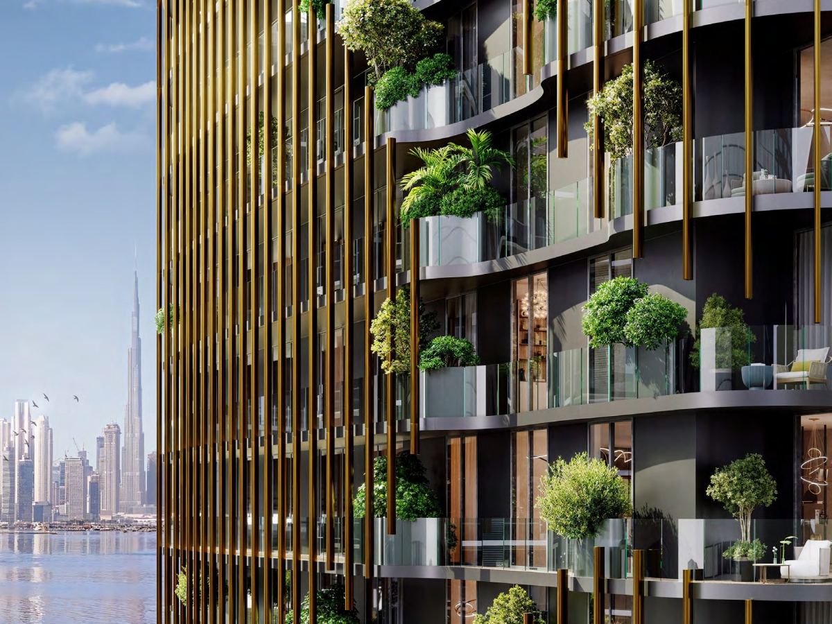 The planted balconies and bronzed fins of the Kanyon façade, with the Dubai skyline beyond.