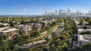 Aerial view of a villa neighbourhood at Marsa Al Saadiyat with a landscaped green corridor running through it and the Abu Dhabi skyline beyond.