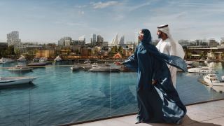 Couple on a terrace above the marina at Marsa Al Saadiyat.