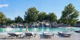 The swimmable forest lagoon at Masaar 3, with landscaped waterfalls and sun loungers.