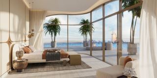 A penthouse bedroom at Ocean House opening onto a terrace over the Arabian Gulf.