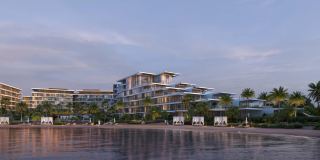 The three stepped buildings of Palm Central seen from the beach at sunset.