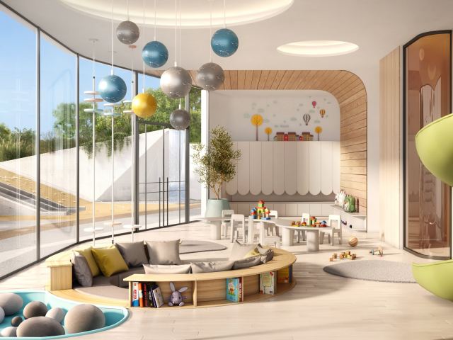 The indoor Kids' Pavilion at Passo, with a slide, a reading nook and a view of the gardens.