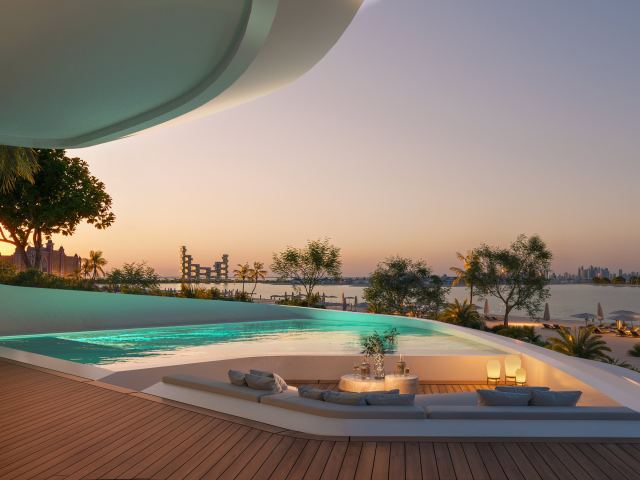 The pool and sunken deck of a beach mansion at Passo at sunset.