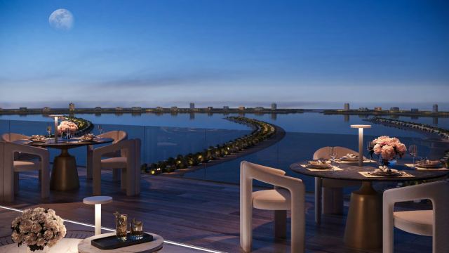 Roof terrace dining at Palm Jebel Ali, looking across the water to the mainland at night
