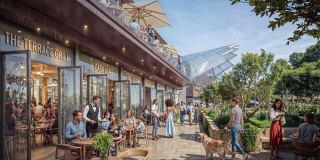 The retail street at Sobha Sanctuary, with cafés, outdoor tables and residents walking between the trees.