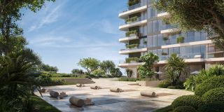 The gardens at Soulever by Beyond, with a tower rising behind and the sea beyond.
