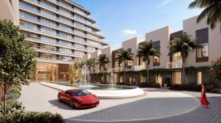 Townhouse-style homes along a landscaped street beside the waterfront district at Sobha City Abu Dhabi.