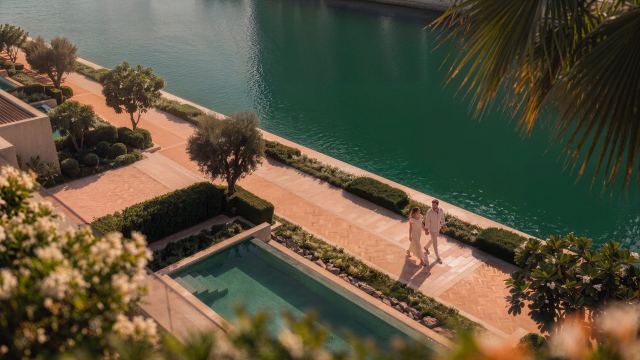 Canal promenade beside a villa pool at Yas Riva Reserve